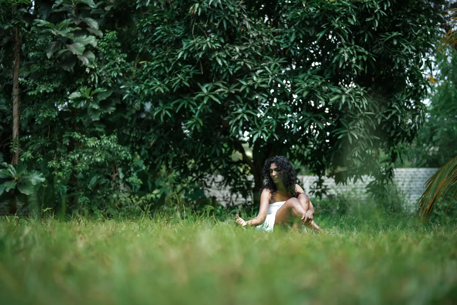 Fine art portrait in a garden, seated