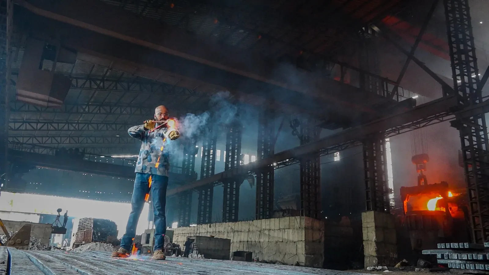 Steel factory worker with sparks