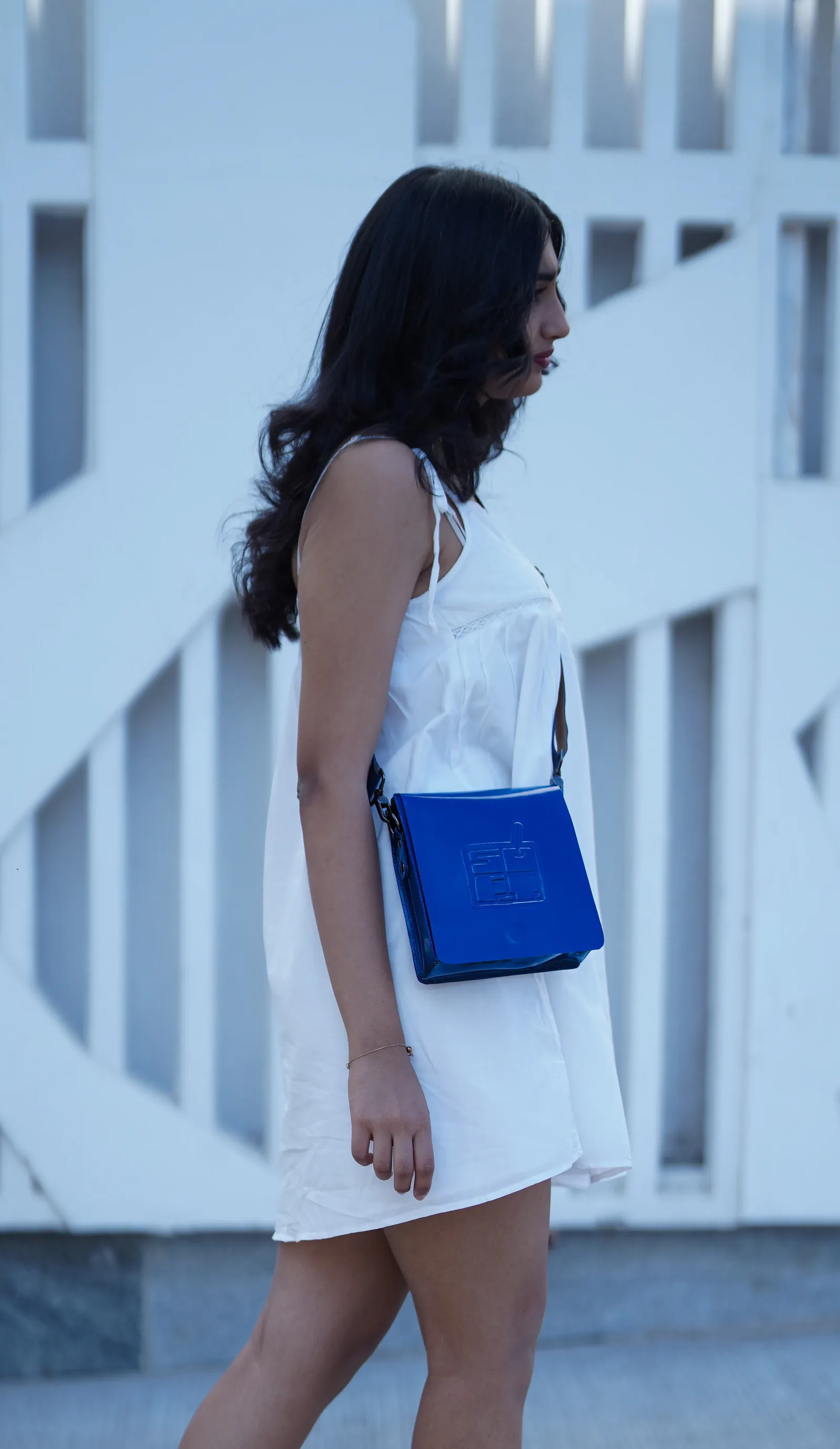 Model with blue bag against geometric backdrop