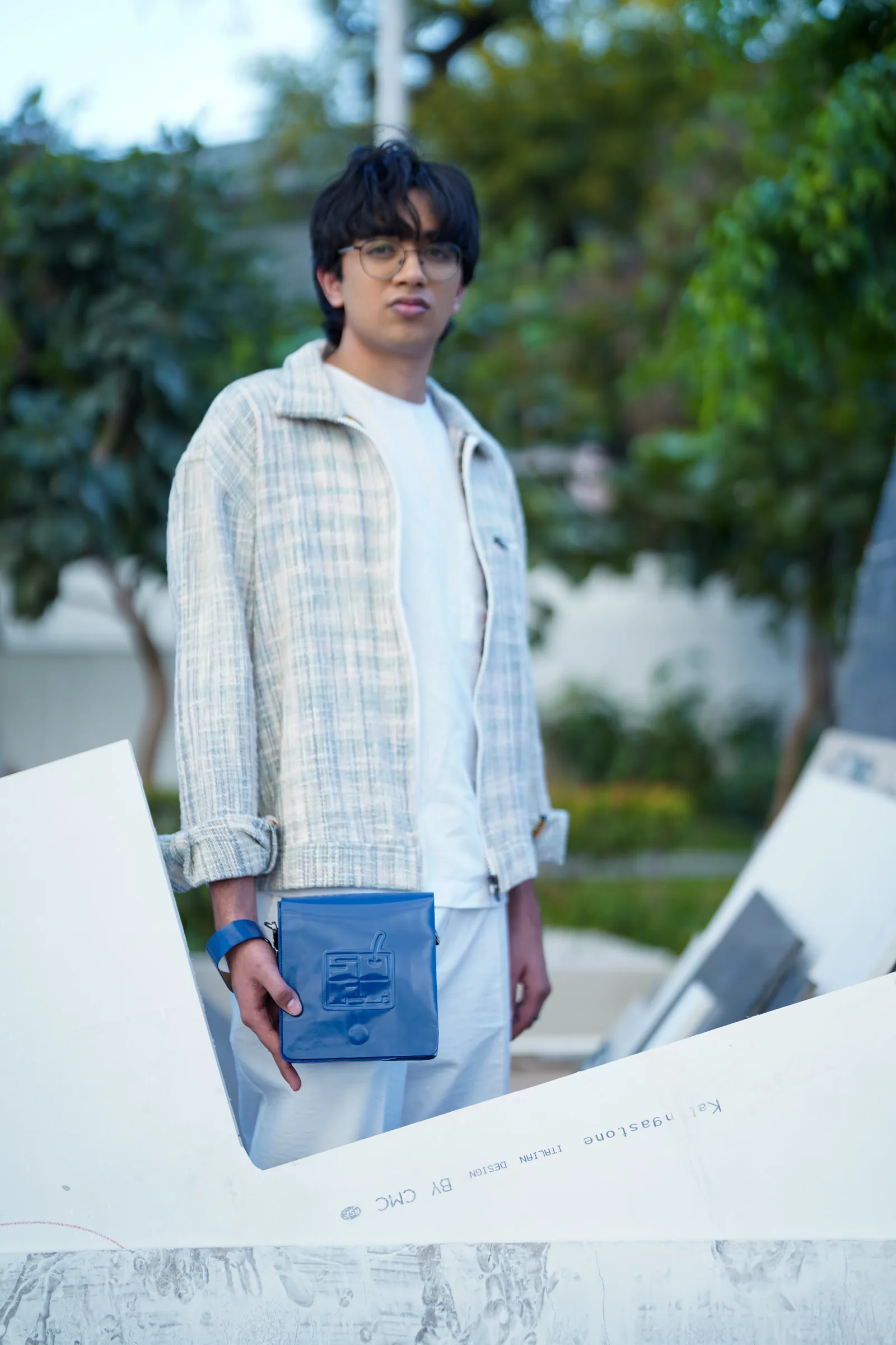 Model with blue bag among sculptural forms